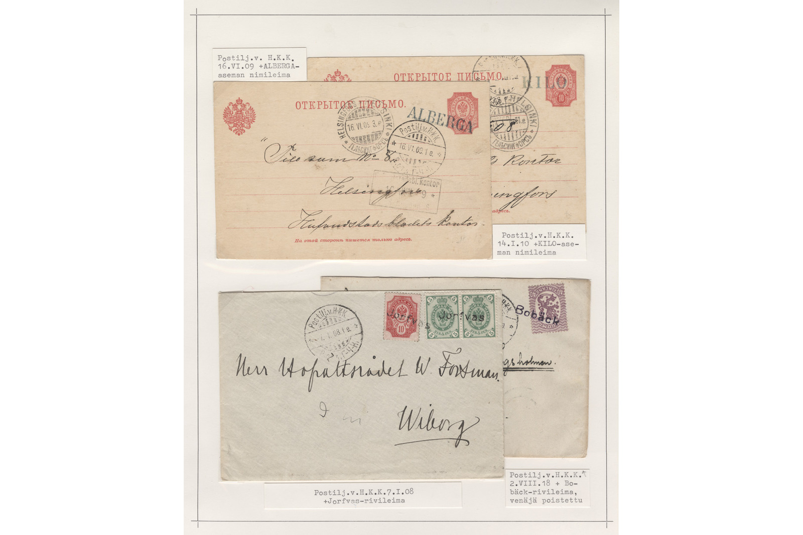 Filateelinen kokoelmasivu, jossa on neljä rautatiepostina kuljetettua lähetystä 1900-luvun alusta konekirjoitettuine seliteteksteineen. Yläosassa on kaksi limittäin asetettua ruskehtavaa venäläistä postikorttia punaisilla painatuksilla ja postimerkeillä; vasemmanpuoleisessa on punainen ”ALBERGA”-leima ja osoite Helsinkiin Hufvudstadsbladetin konttoriin, ja sen vieressä lukee seliteteksti ”Postilj.v. H.K.K. 16.VI.09 +ALBERGA-aseman nimileima”. Oikeanpuoleisen kortin alta löytyy teksti ”Postilj.v.H.K.K. 14.I.10 +KILO-aseman nimileima”. Alaosassa on kaksi limittäistä vaaleaa kirjekuorta; etualalla olevassa kuoressa on kolme postimerkkiä (yksi punainen ja kaksi vihreää), pyöreä leima sekä osoite hovioikeudenneuvos W. Forsmanille Viipuriin, ja sen alla lukee teksti ”Postilj.v.H.K.K. 7.I.08 +Jorvas-rivileima”. Taustalla olevassa kuoressa näkyy violetti postimerkki ja ”Bobäck”-rivileima selitetekstillä ”Postilj.v.H.K.K.* 2.VIII.18 + Bobäck-rivileima, venäjä poistettu”.