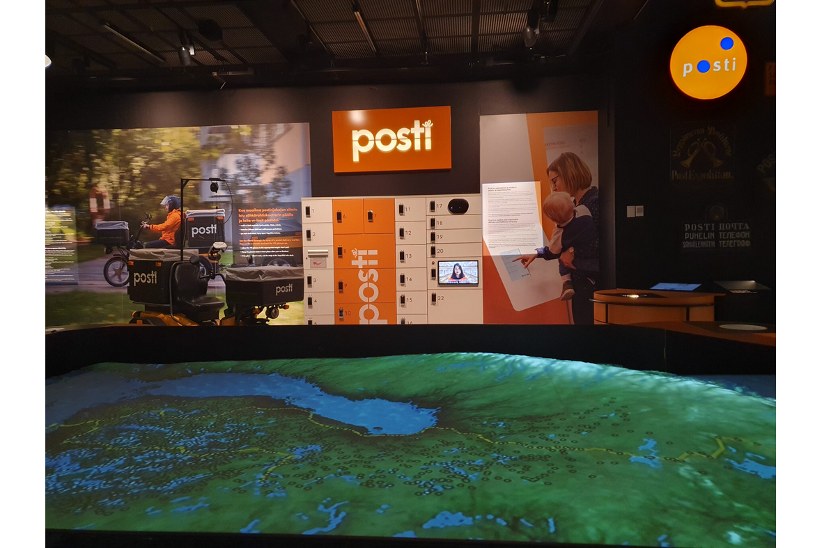 Postimuseon näyttelytilassa näkyy postin logoja ja kartta.
