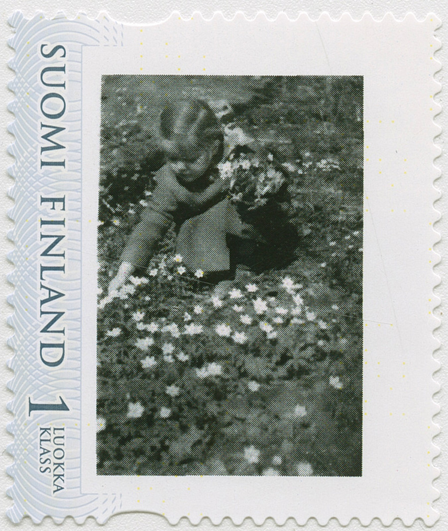Postimerkki, jossa mustavalkoinen kuva tytöstä keräämäsä valkovuokkoja.