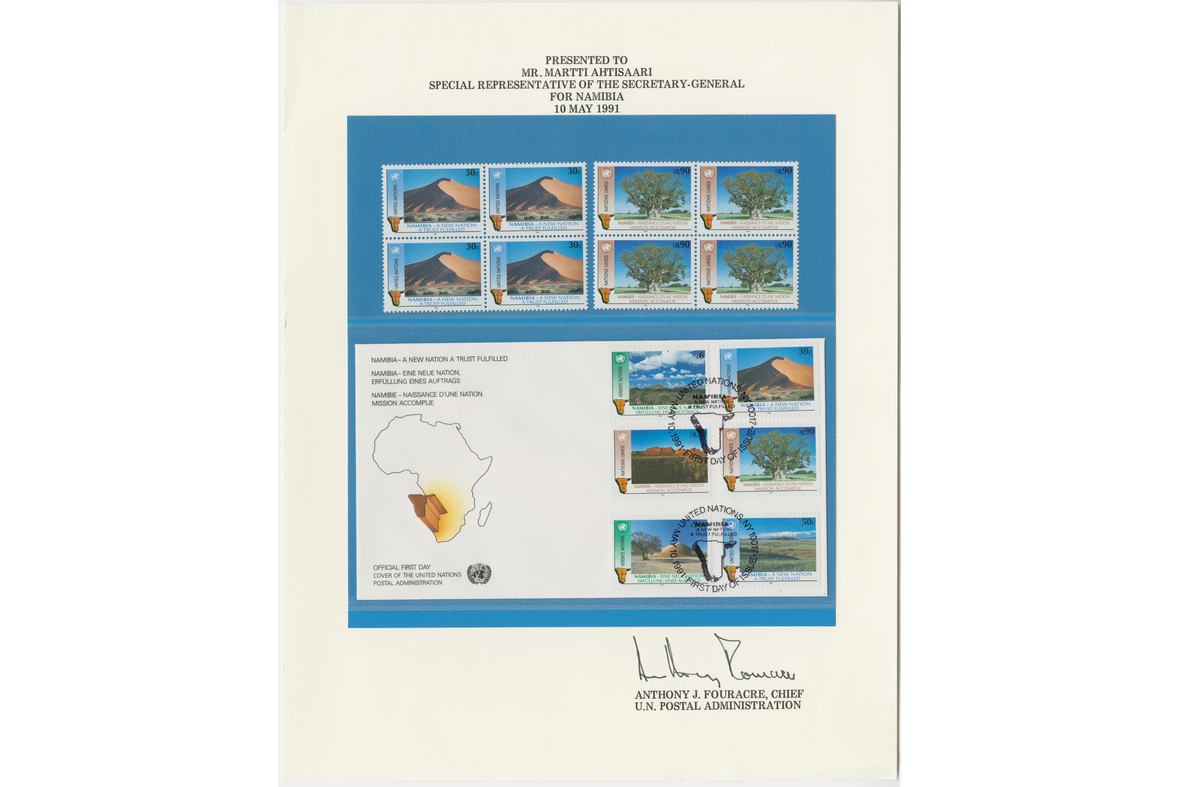 Postimerkkikokoelma sivu, mikä on Anthony J. Fouracren allekirjoituksella varustettuna. Sivulla on sinisellä pohjalla yläpuolella kaksi neljän postimerkin arkkia ja alapuolella on kirjekuori kuudella merkillä sekä kahdella leimalla.
