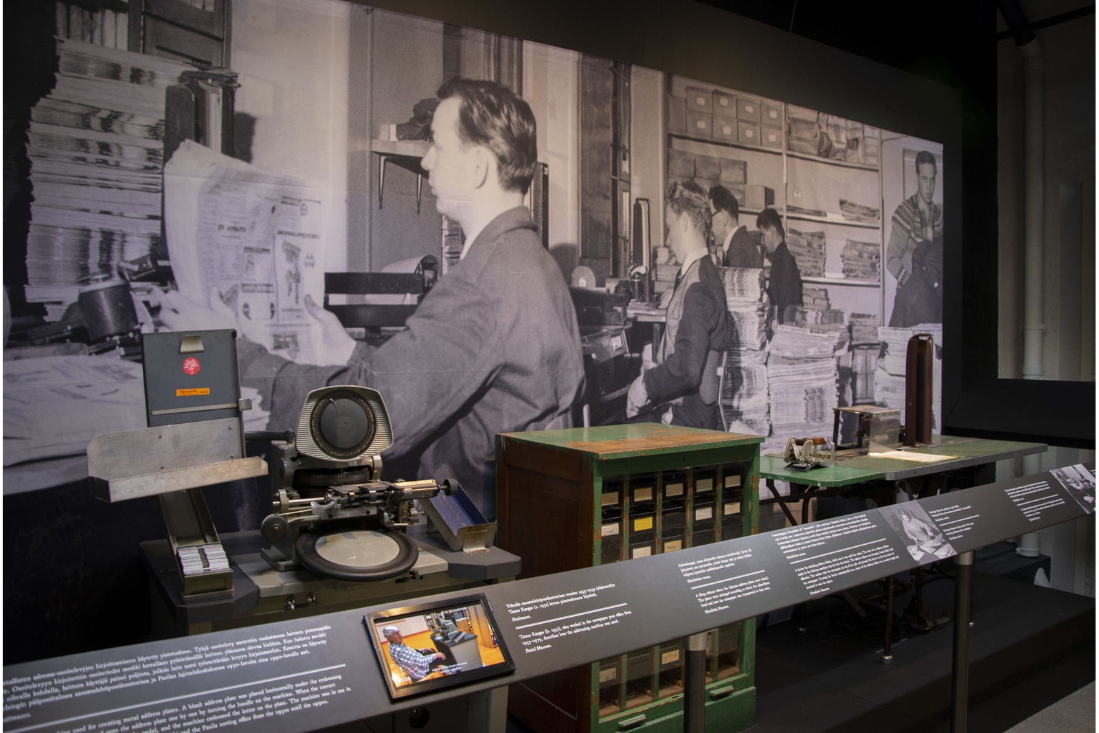 Näyttelytila, jossa iso valtava kuva ja museoesineitä.
