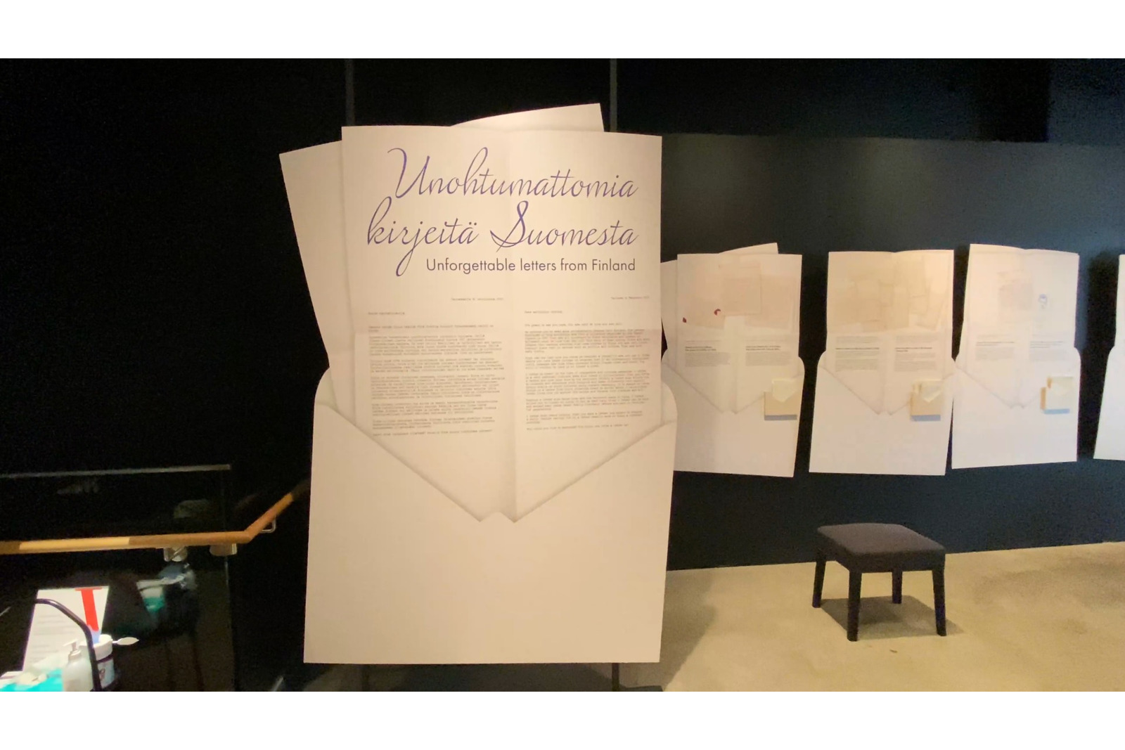 Näyttelytiloista, jossa on valtavissa kirjekuorista paperi osin ulkona. Ensimmäisessä on kaunolla otsikkona Unohtumattomia kirjeitä Suomesta.