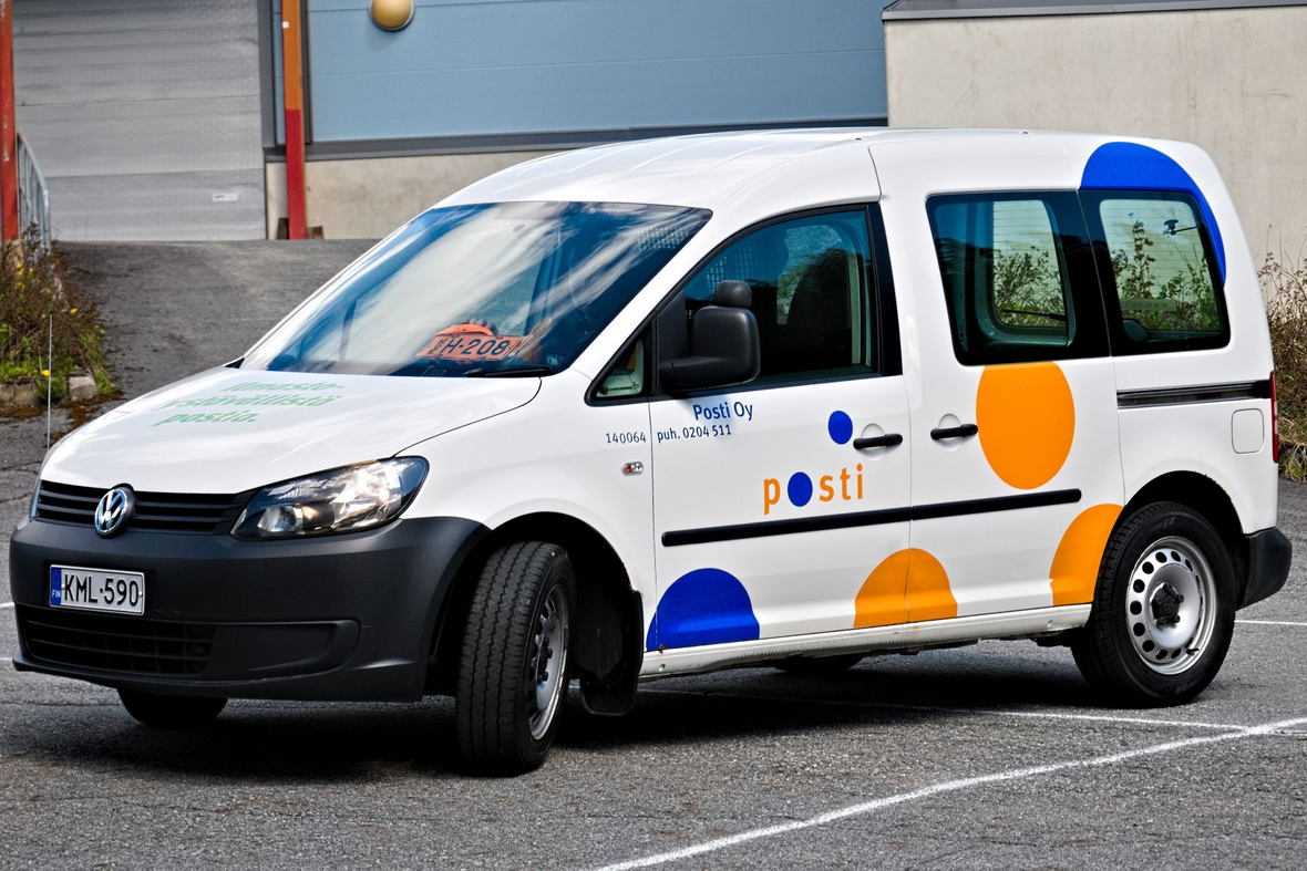Postiauto parkkipaikalla kuvattuna etuviistosta.
