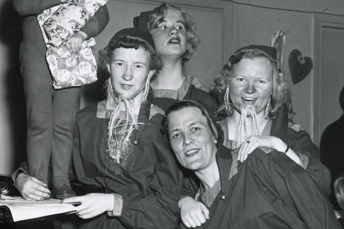 Kuva tonttupukuisista naisista juhlimassa pikkujouluja 1950-luvulla.