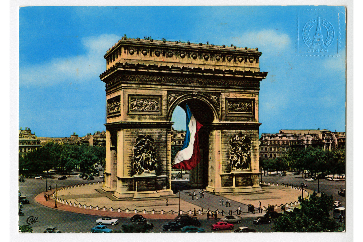 Vaakamallisessa postikortissa on valokuva Pariisin riemukaaresta, jonka keskellä on iso Ranskan lippu. Liikenneympyrässä ympärillä autot liikkuvat, ihmiset kävelevät kohti riemukaarta.