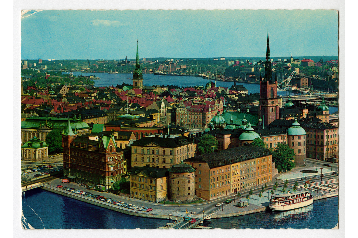 Vaakatasoinen postikortti, jossa on valukuva meren kohdalta Tukholman vanhaan kaupunkiin.