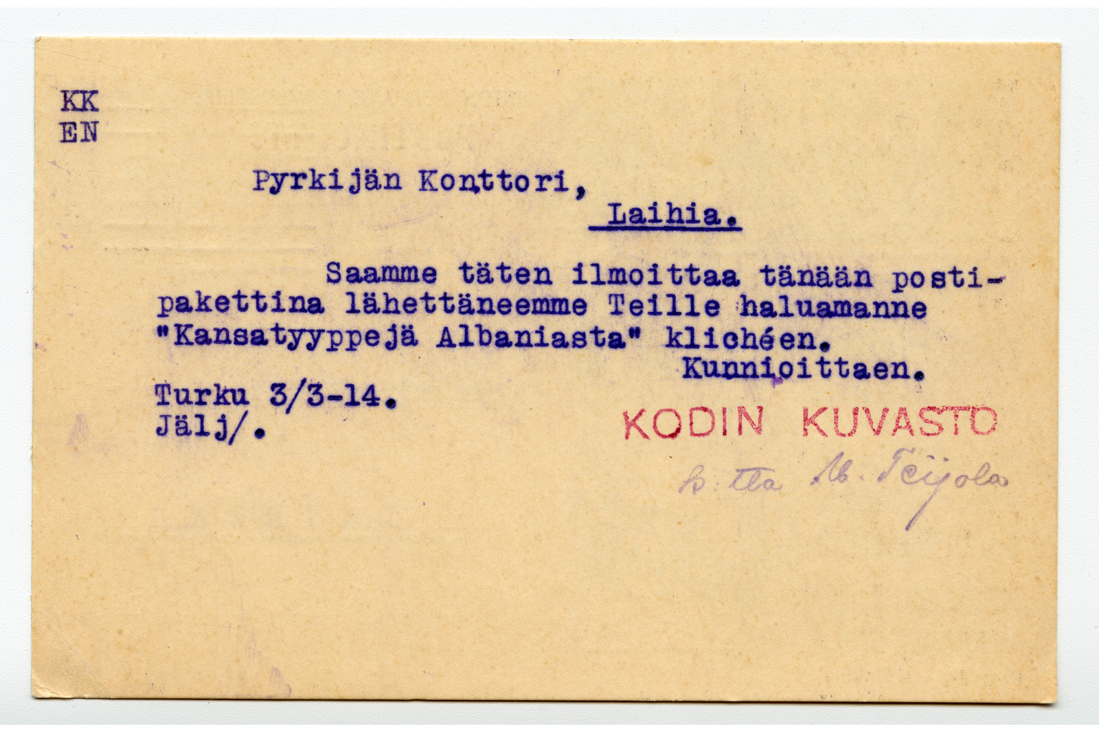 Vaakasuuntaisen kortin takapuoli, jossa on sinisellä musteella kirjoitetut osoitetiedot ja asiateksti, punainen leima sekä käsin tehty allekirjoitus. Kortin yläosassa lukee vastaanottajan tiedot: "Pyrkijän Konttori, Laihia." ja paikkakunnan nimen alla on yhtenäinen viiva. Vasemmassa yläkulmassa on kirjainparit "KK" ja "EN" allekkain. Keskiosassa on lyhyt ilmoitusteksti: "Saamme täten ilmoittaa tänään postipakettina lähettäneemme Teille haluamanne "Kansatyyppejä Albaniasta" klichéen." Tekstin alla vasemmalla on merkinnät "Turku 3/3-14." ja "Jälj/.". Oikealla puolella on lopputervehdys "Kunnioittaen." ja sen alla punaisella musteella painettu leima "Kodin kuvasto". Leiman alapuolella on käsin kirjoitettu allekirjoitus "p. puolesta M. Seijola". Kortissa ei ole postimerkkiä eikä postileimoja.