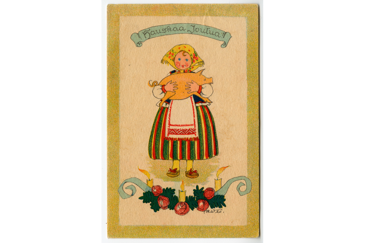 Pystymallinen postikortti, jossa yläpuolella on Hauskaa joulua -teksti, keskellä kansallispukuinen tyttö pitämässä sylissään sikaa ja alla havuköynnös palloilla ja kynttilöillä.