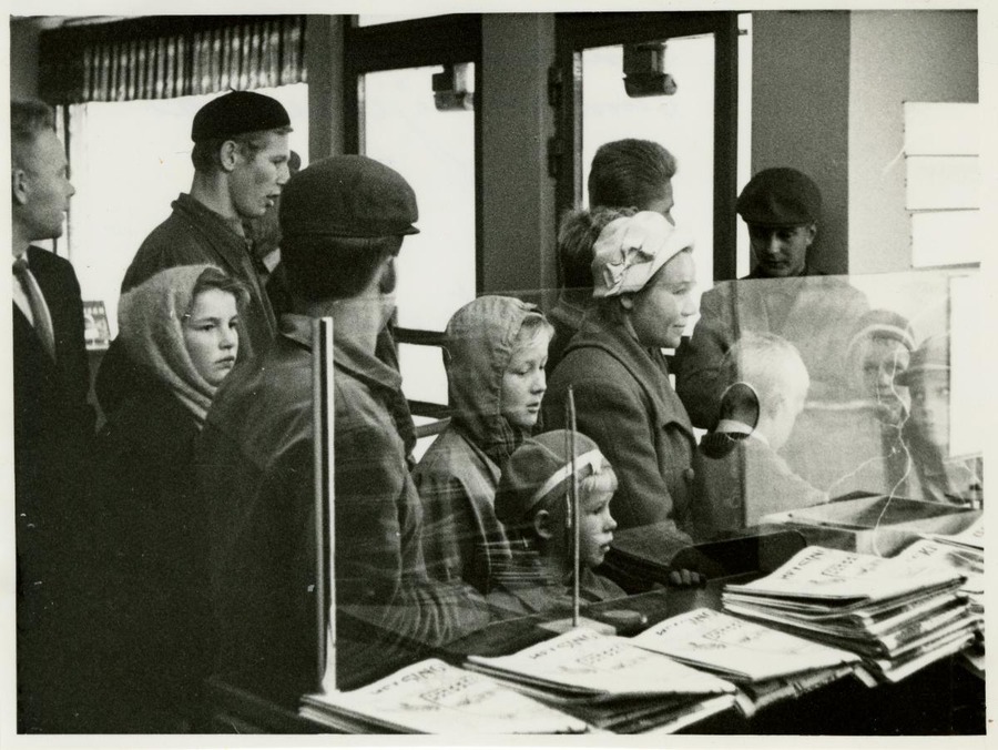 sisällön kuvaus: Sanomalehtien sunnuntaijakelua, lehteä jonotetaan.