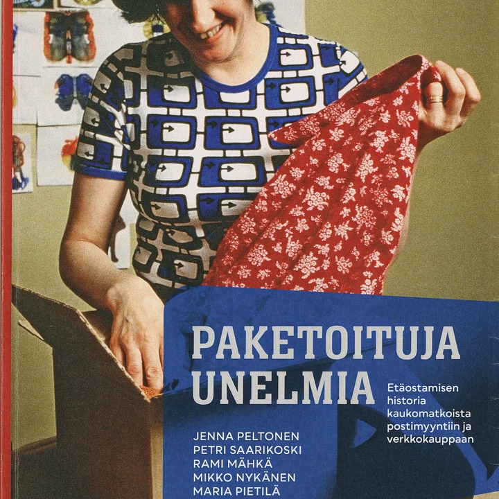 nainen ottaa pahvilaatikosta vaatetta iloisella mielellä.