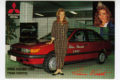 Vaakatasoisessa postikortissa on punaisen auton edessä nuori nainen. Auton ovessa on teksti Miss Suomi 1990. Oikealla yläkulmassa on sama nainen kruunu päässään puolikuvassa, toisessa reunassa on Mitsubishin logo. Alhaalla on teksti Miss Suomi 1990 Tiina Vierto sekä painettu allekirjoitus.