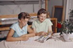 Äiti ja tytär istuvat pöydän ääressä ja täyttävät postimyyntikuvaston tilauslomaketta vuonna 1959.