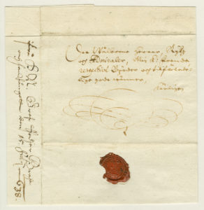 vanha kirje, jossa on merkintä kuriiripostin kyydissä kulkemisesta sekä punainen sinetti.