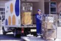 postin työntekijä purkaa postipaketteja kuorma-autosta.