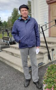 Mies seisoo rakennuksen edessä.