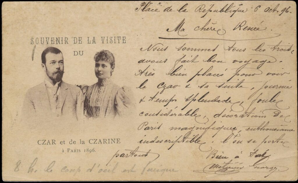 Vaakatasoinen postikortti, jossa painettuna tekstinä mustavalkoisen kuvan ylä- ja alapuolella ranskaksi Souvenir De La Visite du Czar et de la Czarine á Paris 1896 eli Tsaarin ja tsaarinnan vierailun muistoksi Pariisissa 1896. Kuvassa Venäjän keisari Nikolai II ja hänen puolisonsa. Oikealla puolella käsinkirjoitettua tekstiä ranskaksi. Kuva: Olavi Hankimon kokoelma.