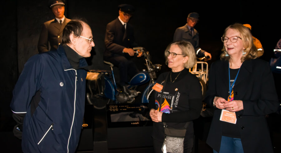 vanhoja ihmisiä hämärässä näyttelytilassa.